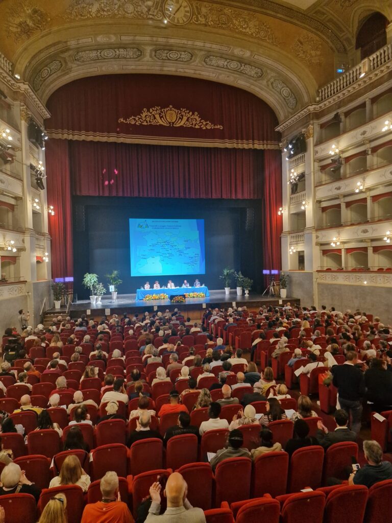 Teatro Goldoni con i partecipanti seduti e i relatori sul palco Teatro Goldoni con i partecipanti seduti e i relatori sul palco